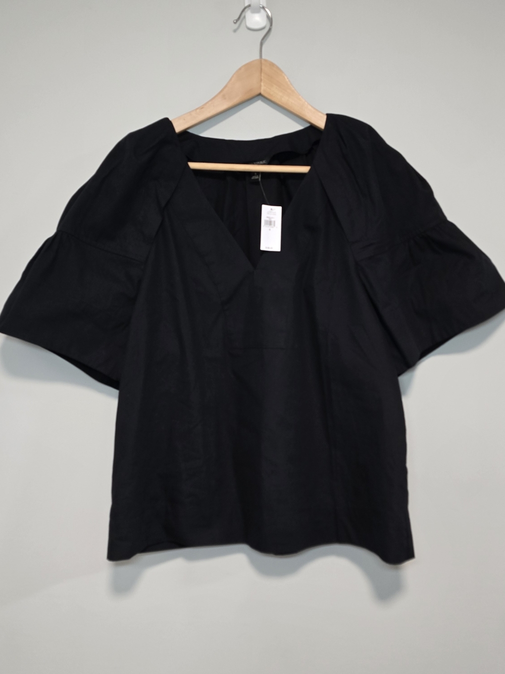 black poplin V-neck popover style short, flared sleeves and pleaded Back